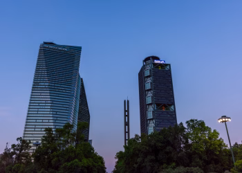 Dramatic view of Mexico City's skyline with prominent skyscrapers under a clear blue sky.