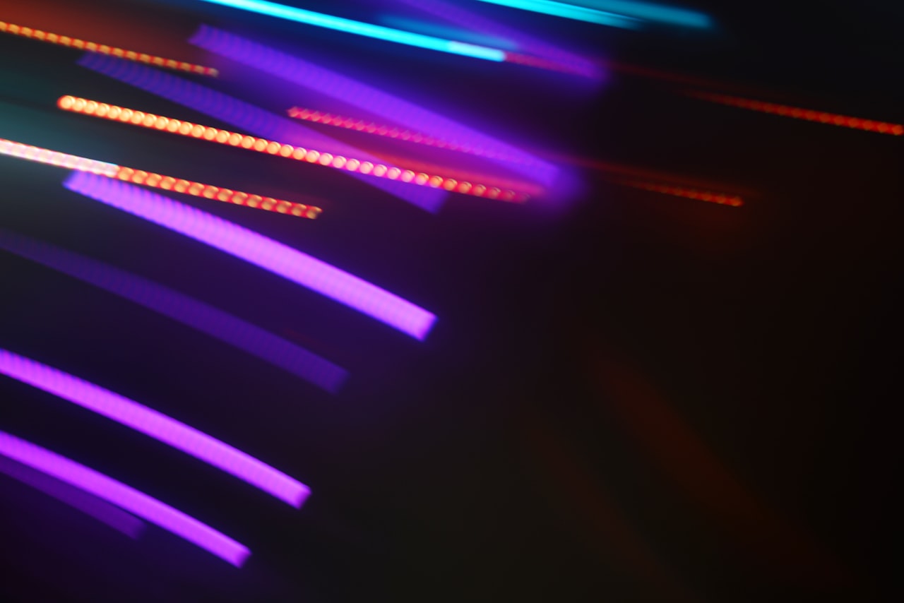 Abstract streaks of colorful neon lights against dark background