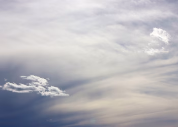 A peaceful cloudy sky with soft, wispy clouds and a calm blue gradient. Perfect background.
