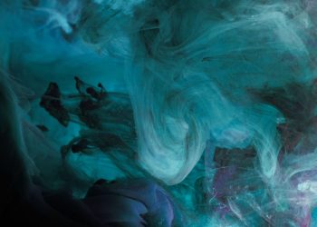 A mesmerizing abstract ink swirl in deep blue tones, creating a fluid and dynamic underwater texture.