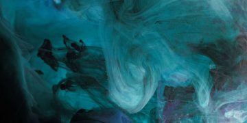 A mesmerizing abstract ink swirl in deep blue tones, creating a fluid and dynamic underwater texture.