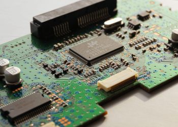 Detailed close-up photo of a circuit board highlighting microchip components and electronic circuits.