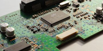 Detailed close-up photo of a circuit board highlighting microchip components and electronic circuits.