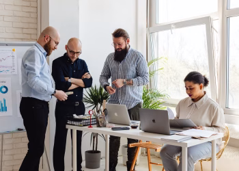 Business professionals collaborating on project in bright modern office space.