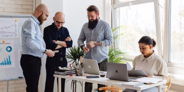 Business professionals collaborating on project in bright modern office space.