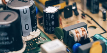 Detailed close-up of capacitors and components on a circuit board, showcasing electronic technology.