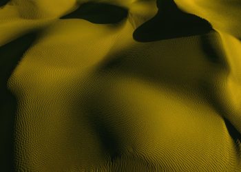 Stunning aerial view of golden sand dunes with artistic shadows and textures.