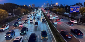 Evening view of busy traffic on a Beijing highway with illuminated city lights.