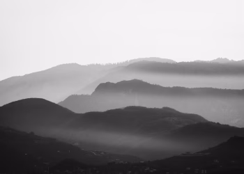 Stunning black and white mountain scene with mist creating a dramatic atmosphere.
