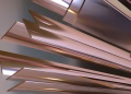 Dynamic abstract design featuring metallic geometric elements with a warm, golden tone.