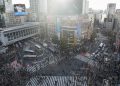 Crowded shibuya crossing with traffic and pedestrians