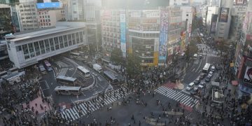 Crowded shibuya crossing with traffic and pedestrians