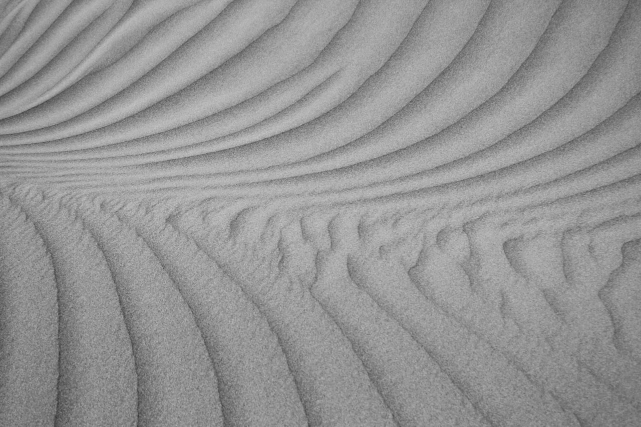 Curved sand dunes create flowing patterns.