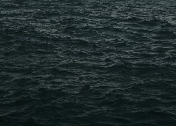 Capture of dark, moody ocean waves at dusk with a dramatic feel.