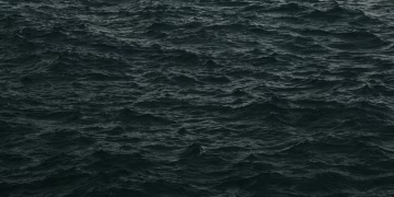 Capture of dark, moody ocean waves at dusk with a dramatic feel.