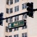 Traffic lights and Wall St sign in cityscape, symbolizing finance hub.