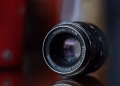 Macro shot of a vintage camera lens reflecting colors in soft focus, showcasing classic optics.