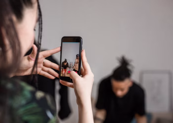 Close-up of a person recording a video with a smartphone indoors, focusing on creative content creation.