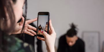 Close-up of a person recording a video with a smartphone indoors, focusing on creative content creation.