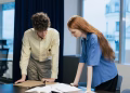 Business professionals collaborating on a project in a modern office space.
