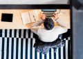 man sitting by the desk using laptop computer