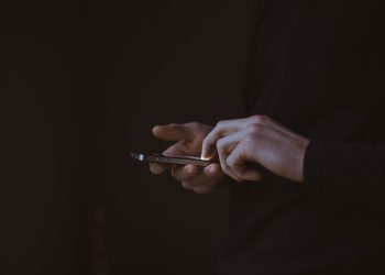 silhouette photo of person holding smartphone