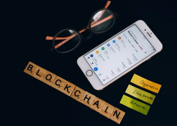 Smartphone displaying cryptocurrency market data alongside blockchain concept elements.