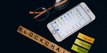 Smartphone displaying cryptocurrency market data alongside blockchain concept elements.