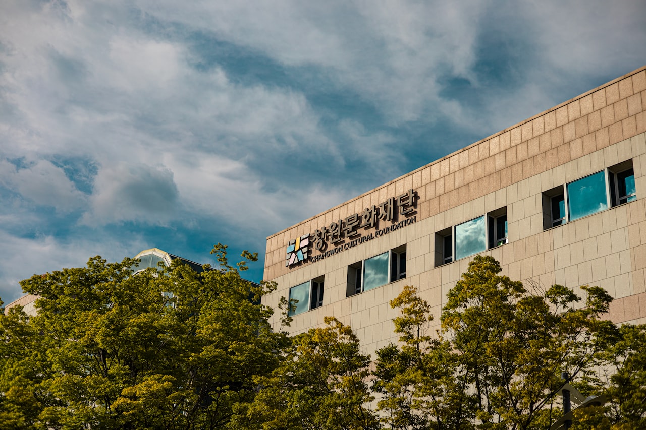 a tall building with a sky background and trees in the foreground