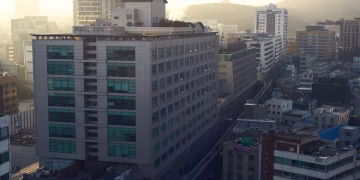 Aerial shot of a densely built urban area with modern architecture during sunset.