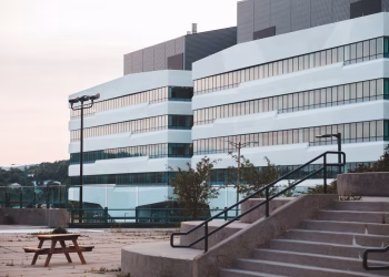 A modern office building and urban landscape captured at sunset, showcasing architecture and open social space.