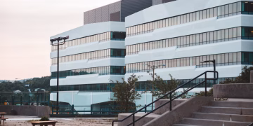 A modern office building and urban landscape captured at sunset, showcasing architecture and open social space.