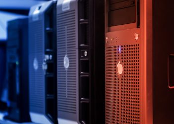 Close-up of tower servers in a data center with blue and red lighting.