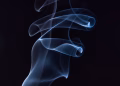 Artistic capture of swirling blue smoke against a black background, highlighting motion and elegance.