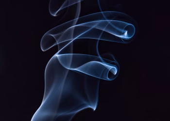 Artistic capture of swirling blue smoke against a black background, highlighting motion and elegance.