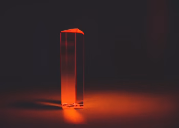 A striking image of a red prism casting shadows in a dark setting, creating a mysterious atmosphere.