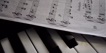 A detailed view of piano keys alongside a sheet of musical notation, emphasizing harmony.