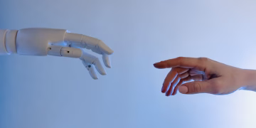 A human hand reaching towards a robotic hand symbolizing technology and connection.