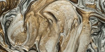 Elegant marbled art pattern with swirling golden and silver hues. Perfect for abstract art lovers.