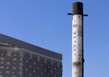 A SpaceX Falcon 9 rocket displayed outdoors against a clear blue sky in Dubai.