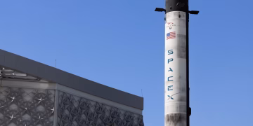 A SpaceX Falcon 9 rocket displayed outdoors against a clear blue sky in Dubai.