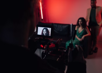 Behind the scenes of a studio filming session focused on actors within a creative setup.