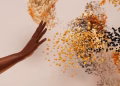Creative concept depicting a hand reaching towards abstract swirling particles.