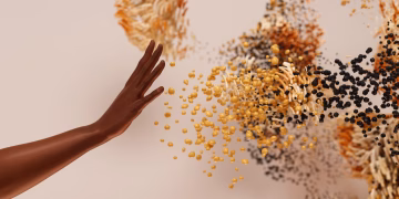 Creative concept depicting a hand reaching towards abstract swirling particles.