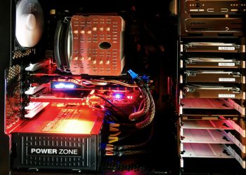 Close-up of a custom gaming PC with RGB lighting, showcasing power supply and components.