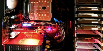 Close-up of a custom gaming PC with RGB lighting, showcasing power supply and components.