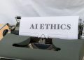 Close-up of vintage typewriter with 'AI ETHICS' typed on paper, emphasizing technology and responsibility.