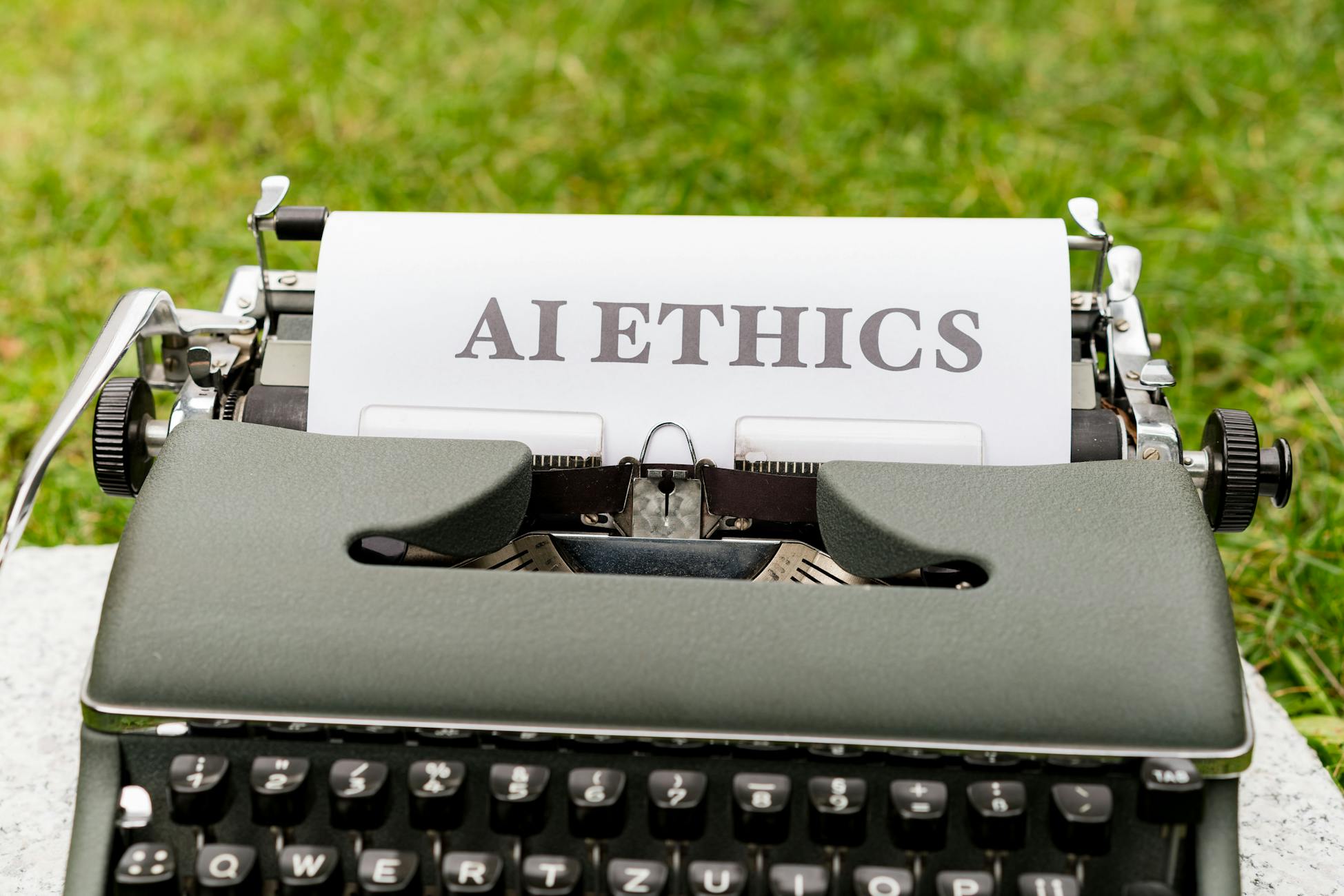 A vintage typewriter outdoors displaying 'AI ethics' on paper, symbolizing tradition meets technology.