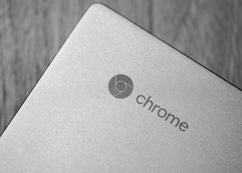 Detailed grayscale image focusing on a Chrome laptop logo, highlighting texture and design.