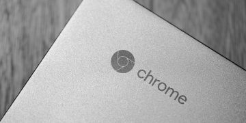 Detailed grayscale image focusing on a Chrome laptop logo, highlighting texture and design.